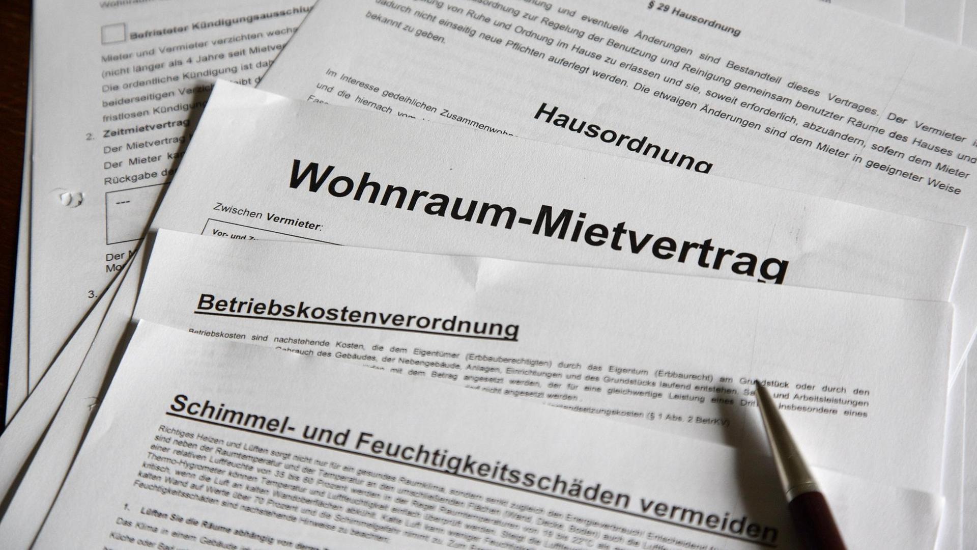 Ein Mietvertrag liegt aufgefächert auf einem Tisch. Ein Mietvertrag liegt aufgefächert auf einem Tisch.