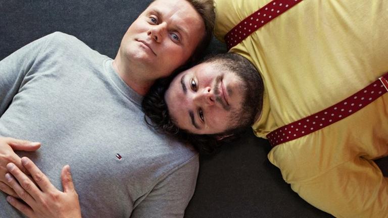 Devid Striesow und Axel Ranisch liegen auf dem Boden, die Köpfe nebeneinander Devid Striesow und Axel Ranisch liegen auf dem Boden, die Köpfe nebeneinander
