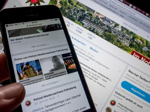 Auf einem Smartphone ist die Facebook-Seite des Landeskriminalamtes Niedersachsen und im Hintergrund auf einem PC-Display die Twitter-Seite der Polizei Niedersachsen. Bei der Verbrecherjagd, Suche nach vermissten Personen oder in Terrorlagen sind die sozialen Medien für die Polizei in Deutschland inzwischen unverzichtbar.