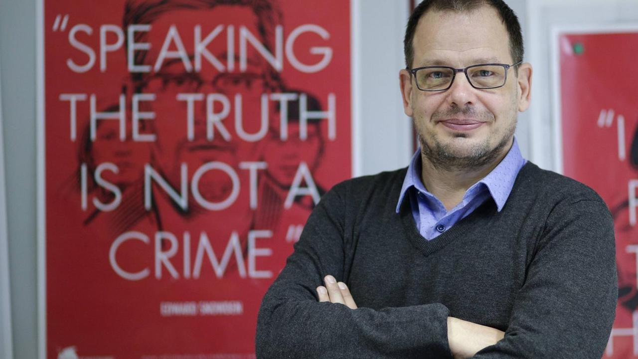 Hajo Seppelt vor einem roten Poster mit der Aufschrift: "Speaking the truth is not a crime" (zu deutsch: "Die Wahrheit zu sagen, ist kein Verbrechen"). 