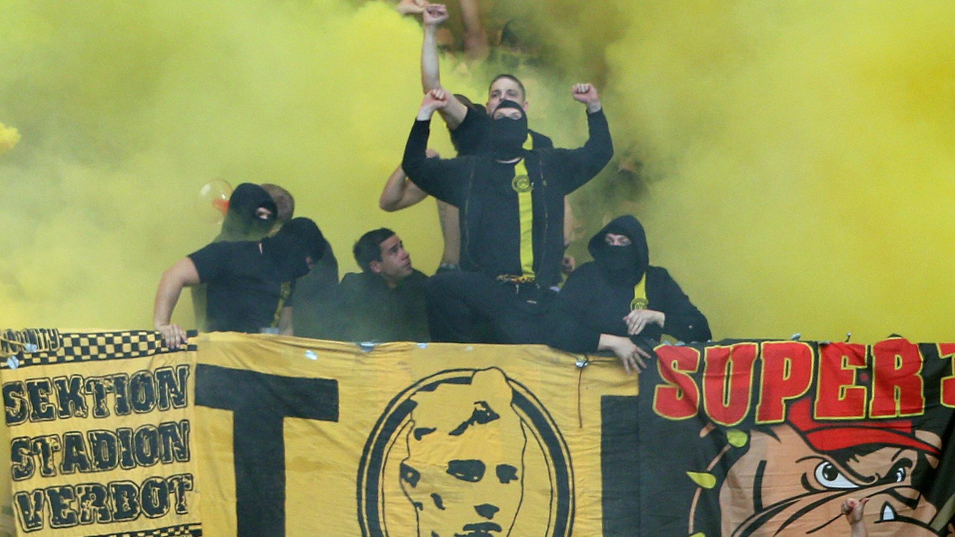 Fußball Bundesliga, 10. Spieltag, FC Schalke 04 - Borussia Dortmund am 26.10.2013 in der VeltinsArena in Gelsenkirchen (Nordrhein-Westfalen). Vermummte Dortmunds Fans stehen auf dem Zaun des Gästeblocks, nach dem Zünden von Feuerwerken. Foto: Friso Gentsch/dpa (zu dpa-KORR: «Nach Pyro-Ausschreitungen: Konsequente Aufarbeitung angestrebt» vom 28.10.2013) | Verwendung weltweit Fußball Bundesliga, 10. Spieltag, FC Schalke 04 - Borussia Dortmund am 26.10.2013 in der VeltinsArena in Gelsenkirchen (Nordrhein-Westfalen). Vermummte Dortmunds Fans stehen auf dem Zaun des Gästeblocks, nach dem Zünden von Feuerwerken. Foto: Friso Gentsch/dpa (zu dpa-KORR: «Nach Pyro-Ausschreitungen: Konsequente Aufarbeitung angestrebt» vom 28.10.2013) | Verwendung weltweit