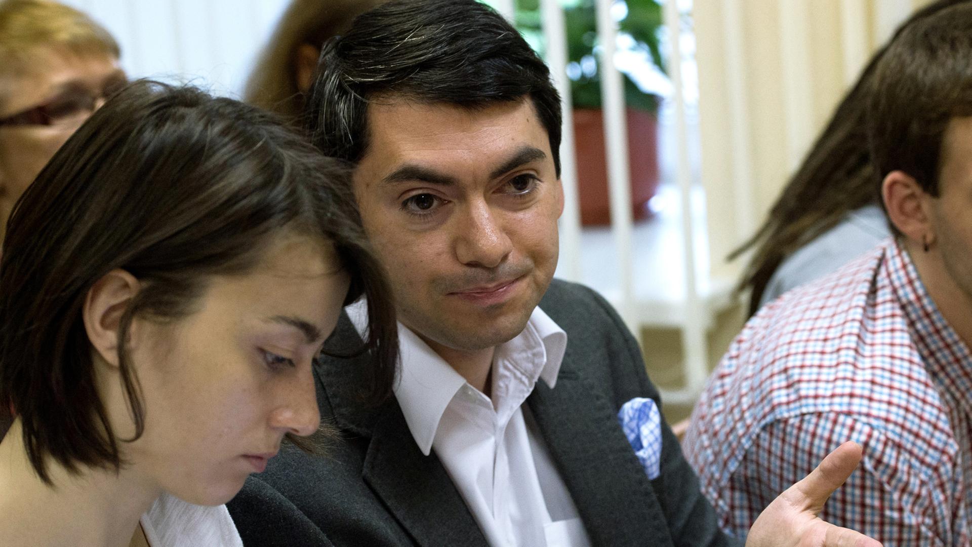 Grigorij Melkonjants, Leiter der NGO "Golos" in Russland, sitzt neben einer Frau, gestikuliert mit einer Hand Grigorij Melkonjants, Leiter der NGO "Golos" in Russland, sitzt neben einer Frau, gestikuliert mit einer Hand