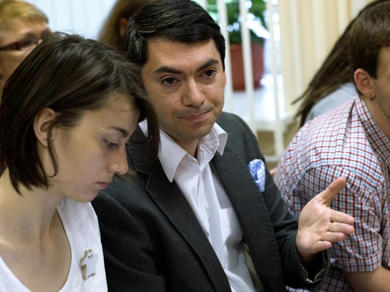 Grigorij Melkonjants, Leiter der NGO "Golos" in Russland, sitzt neben einer Frau, gestikuliert mit einer Hand