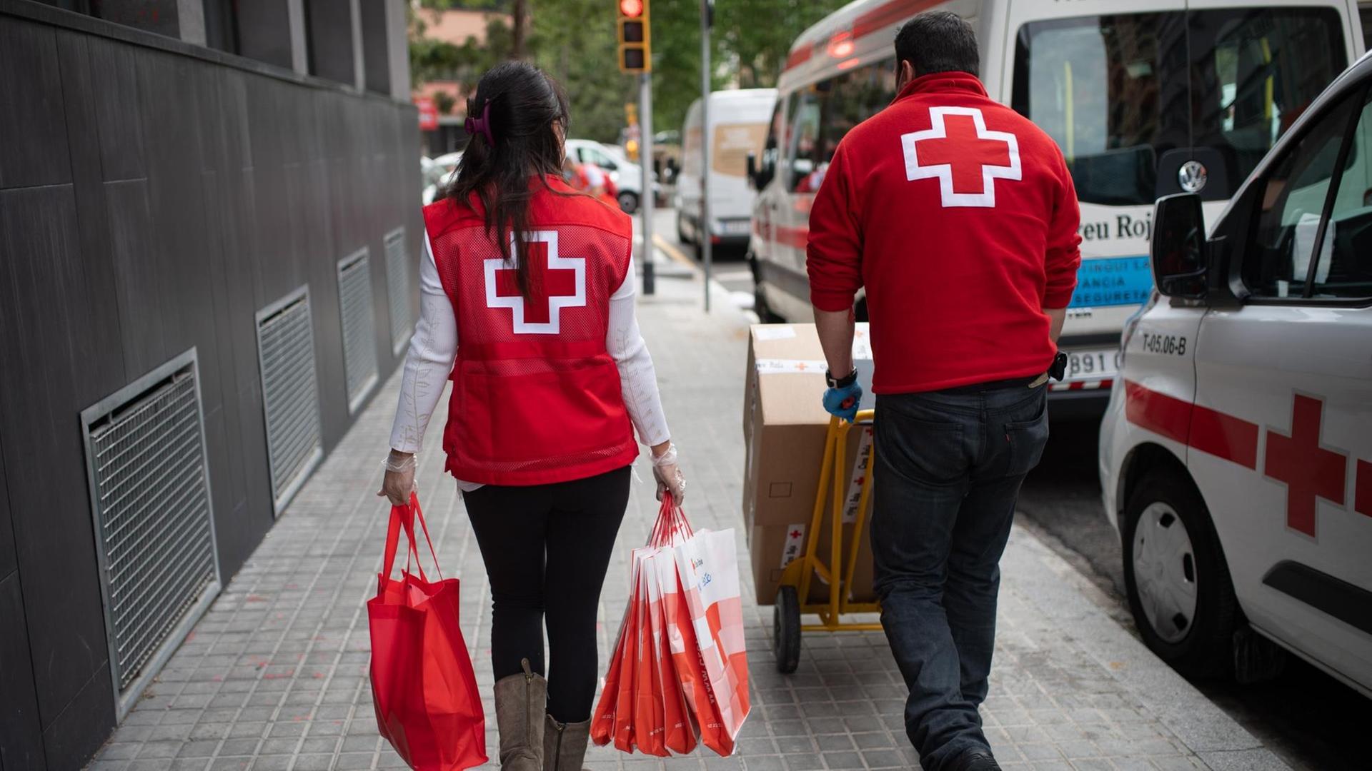 Mitarbeiter des Roten Kreuz versorgen Bedürftige und bringen ihnen Lebensmittel Mitarbeiter des Roten Kreuz versorgen Bedürftige und bringen ihnen Lebensmittel