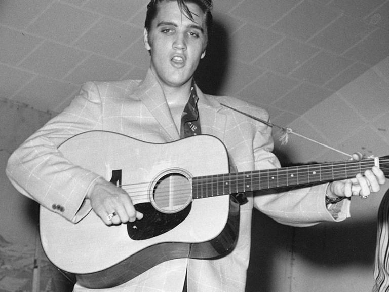 Elvis spielt Gitarre bei einem Konzert in Texas.