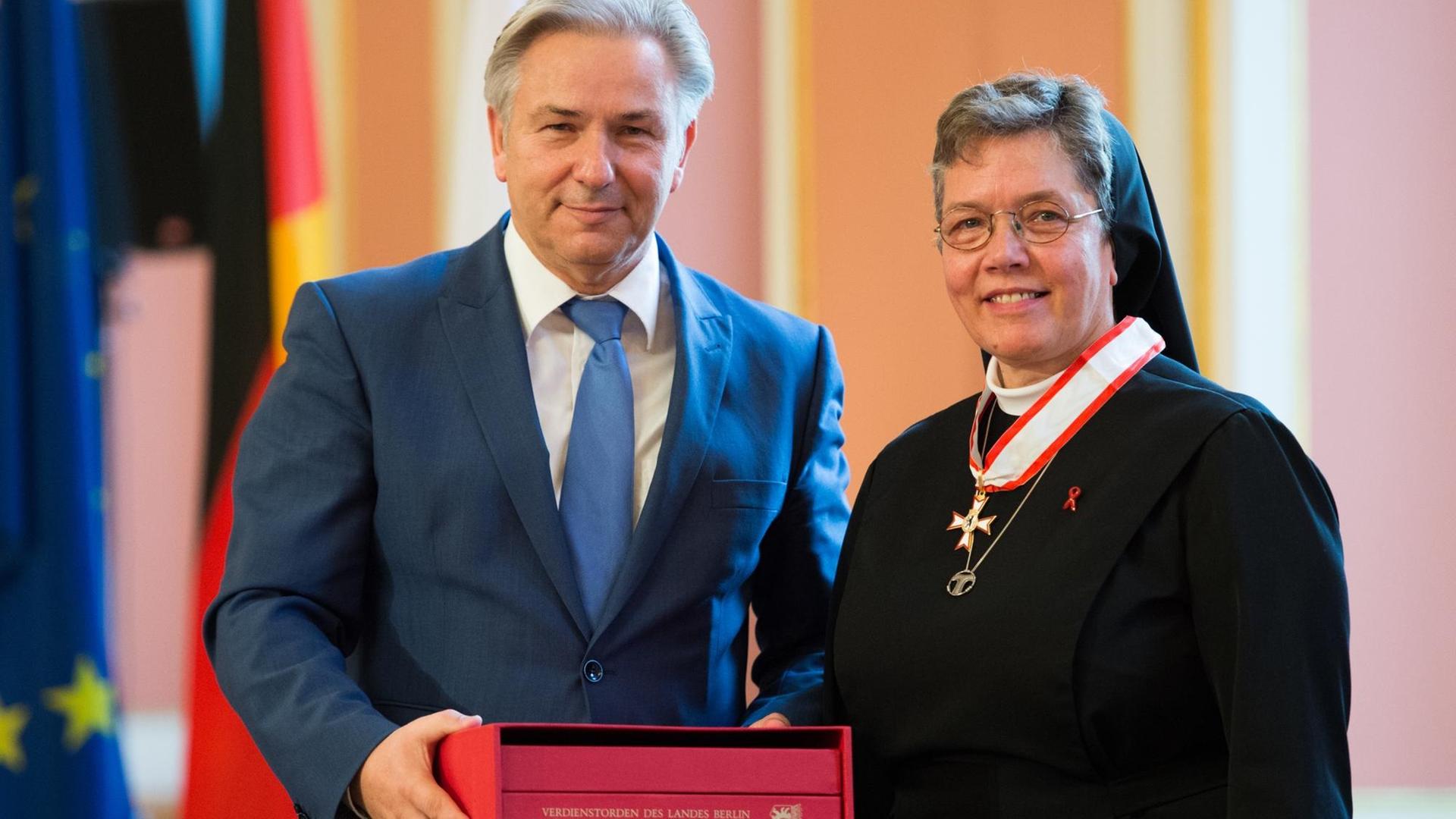 Der damalige regierende Bürgermeister Klaus Wowereit verleiht am 1.10.2014 den Verdienstorden des Landes Berlin an Schwester Maria Hannelore Huesmann für ihr Engagement bei "Tauwerk". Der damalige regierende Bürgermeister Klaus Wowereit verleiht am 1.10.2014 den Verdienstorden des Landes Berlin an Schwester Maria Hannelore Huesmann für ihr Engagement bei "Tauwerk".