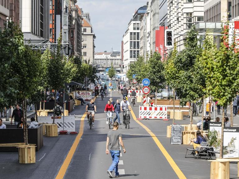 Radfahrer, Rollerfahrer und Fußgänger sind auf der autofreien Berliner Friedrichstrasse unterwegs. Auf einem 500 Meter langen Abschnitt ist der Verkehr für Autos bis Ende Januar 2021 gesperrt.
