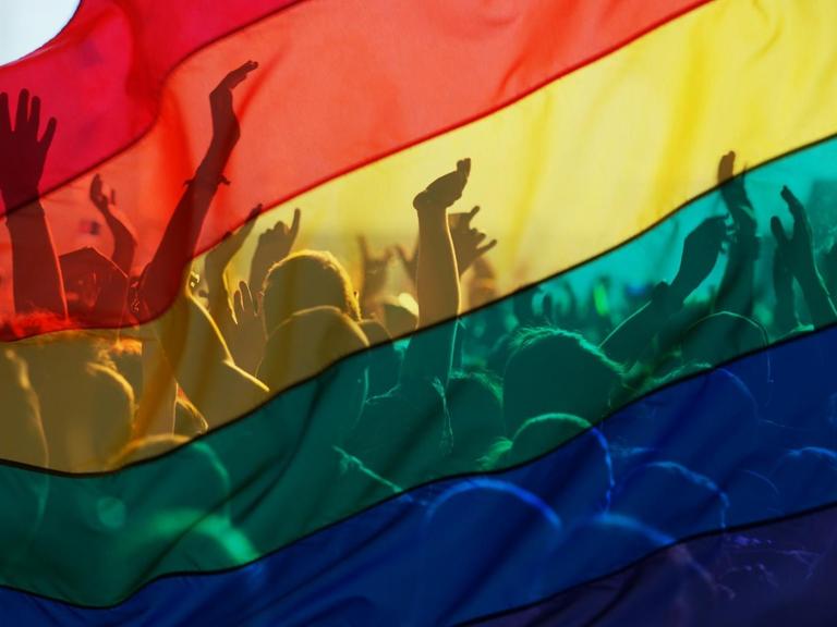 Teilnehmer einer Schwulen- und Lesbenparade mit einer Regenbogenfahne, als Symbol von Liebe und Toleranz