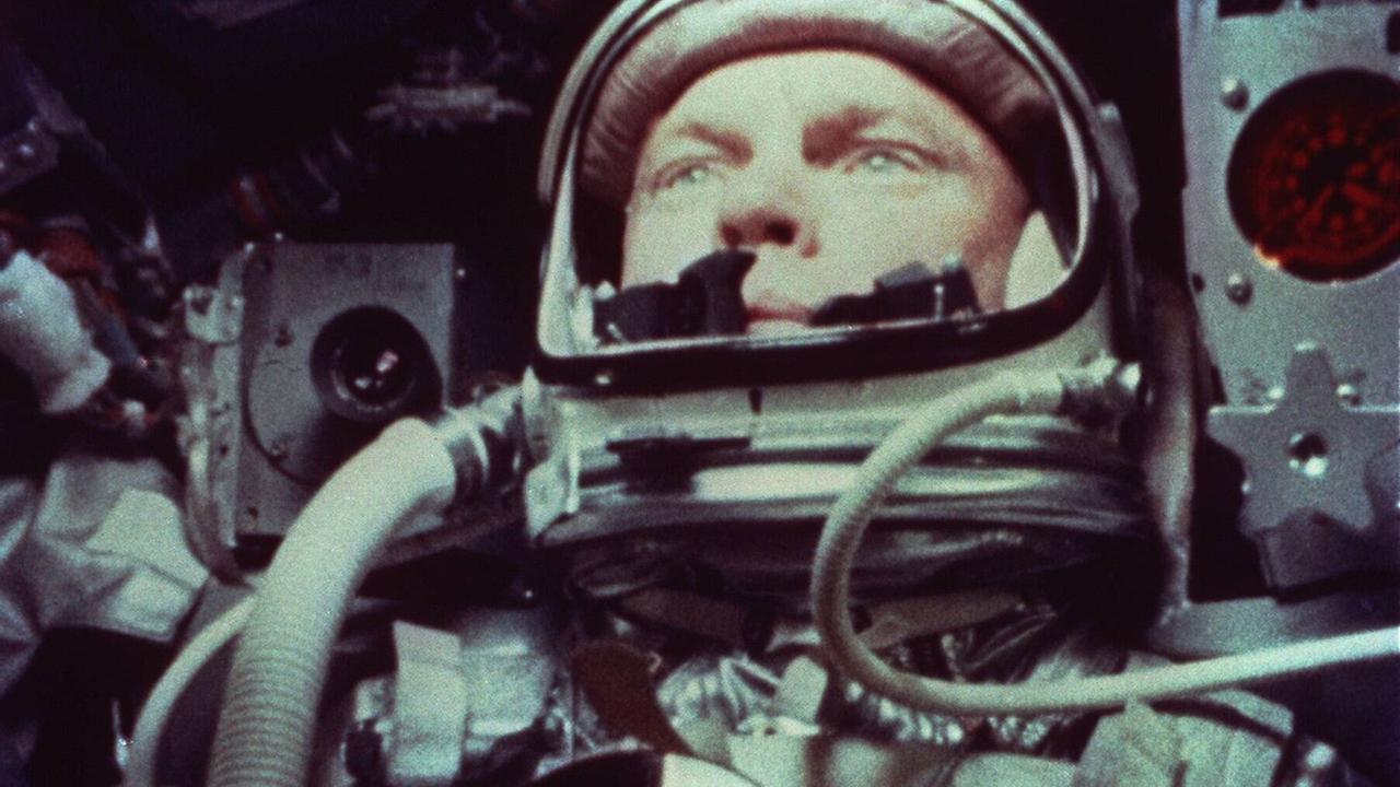 Der Astronaut John Glenn in Anzug, verkabelt und zwischen Technik in einer Raumkapsel sitzend. Der Astronaut John Glenn in Anzug, verkabelt und zwischen Technik in einer Raumkapsel sitzend.