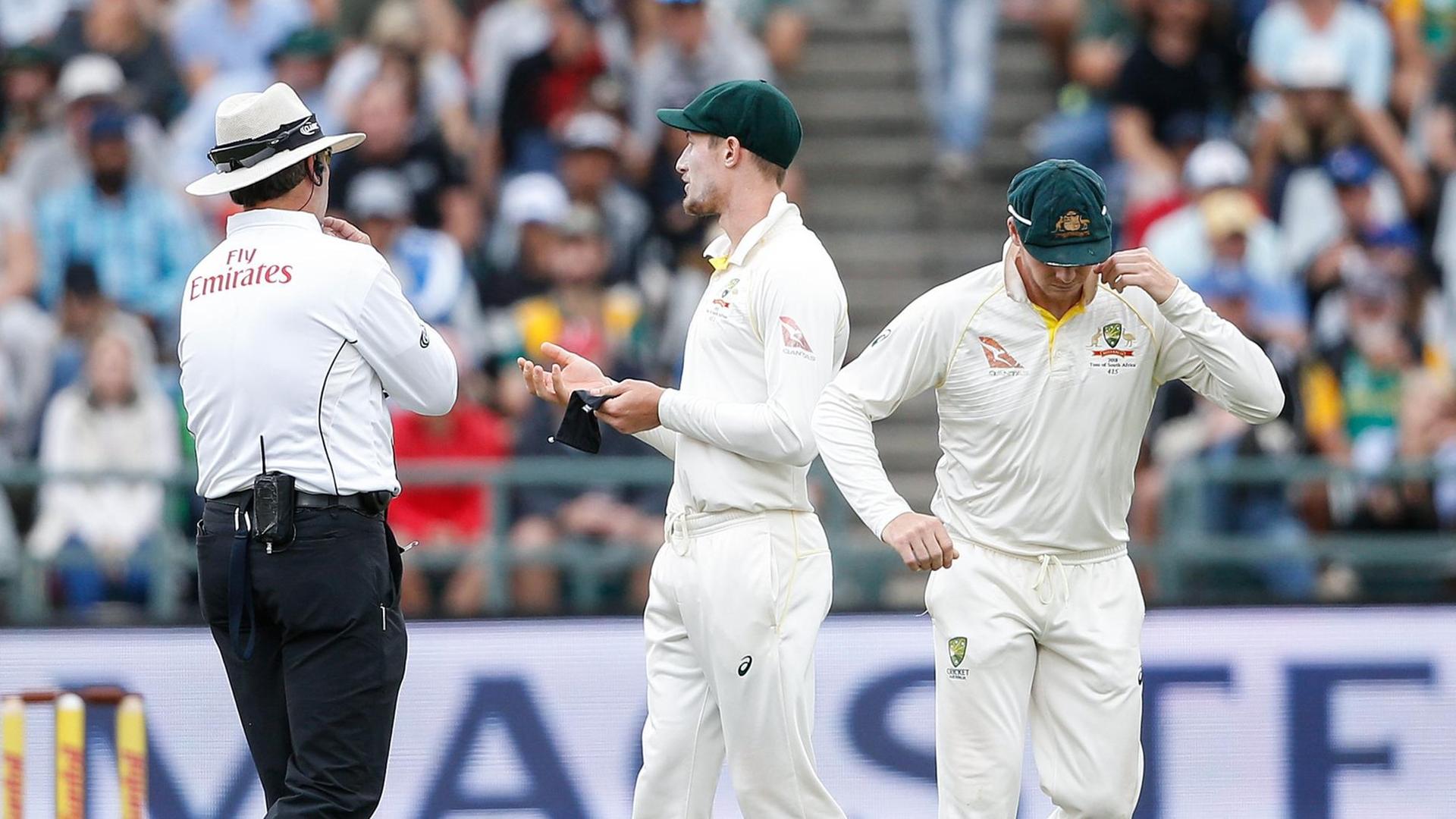 Der australische Schlagman Cameron Bancroft wird beim Testspiel gegen Südafrika in Kapstadt von Schiedsrichtern befragt. Der australische Schlagman Cameron Bancroft wird beim Testspiel gegen Südafrika in Kapstadt von Schiedsrichtern befragt.