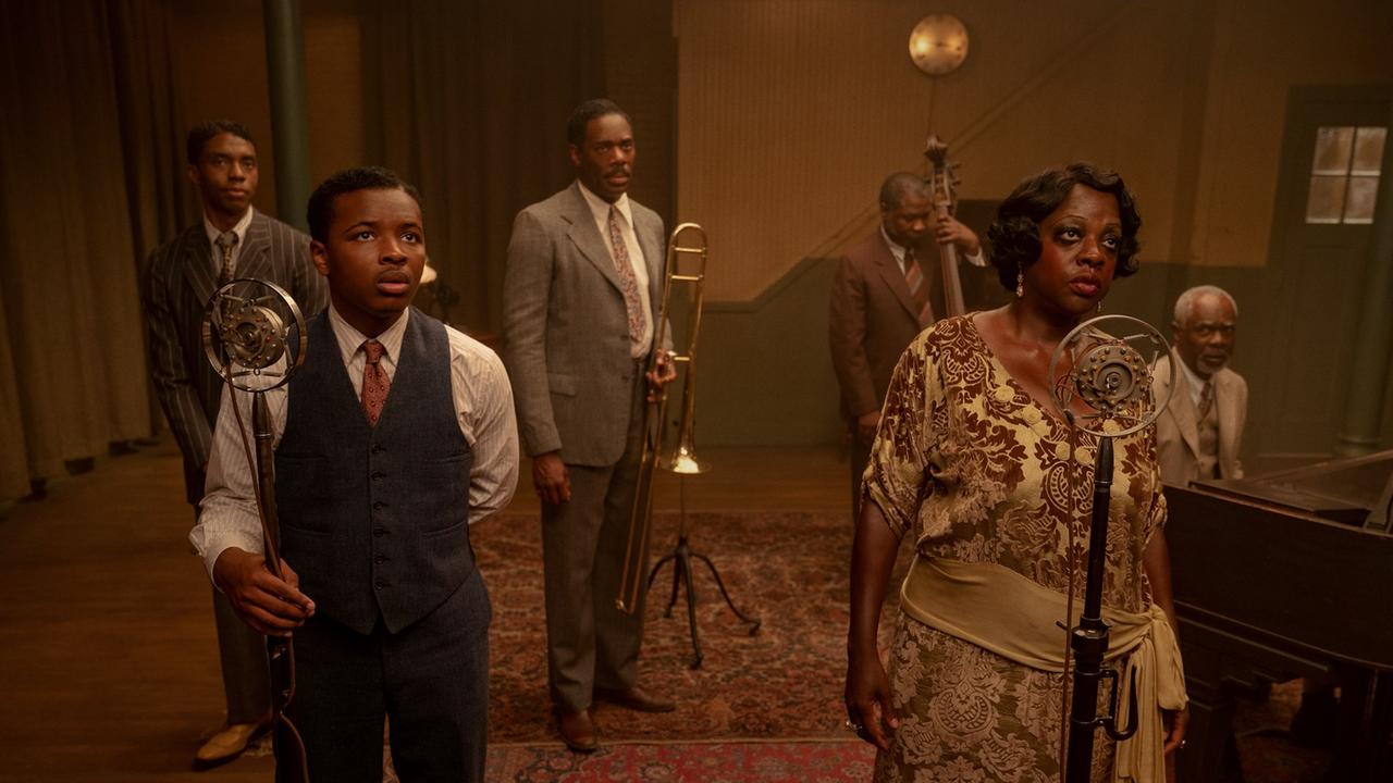 Filmszene aus Ma Rainey's Black Bottom (2020): Von links nach rechts sind bei einer Probe zu sehen: Chadwick Boseman ("Levee"), Dusan Brown ("Sylvester"), Colman Domingo ("Cutler"), Michael Potts ("Slow Drag"), Viola Davis ("Ma Rainey"), Glynn Turman ("Toldeo"). Filmszene aus Ma Rainey's Black Bottom (2020): Von links nach rechts sind bei einer Probe zu sehen: Chadwick Boseman ("Levee"), Dusan Brown ("Sylvester"), Colman Domingo ("Cutler"), Michael Potts ("Slow Drag"), Viola Davis ("Ma Rainey"), Glynn Turman ("Toldeo").