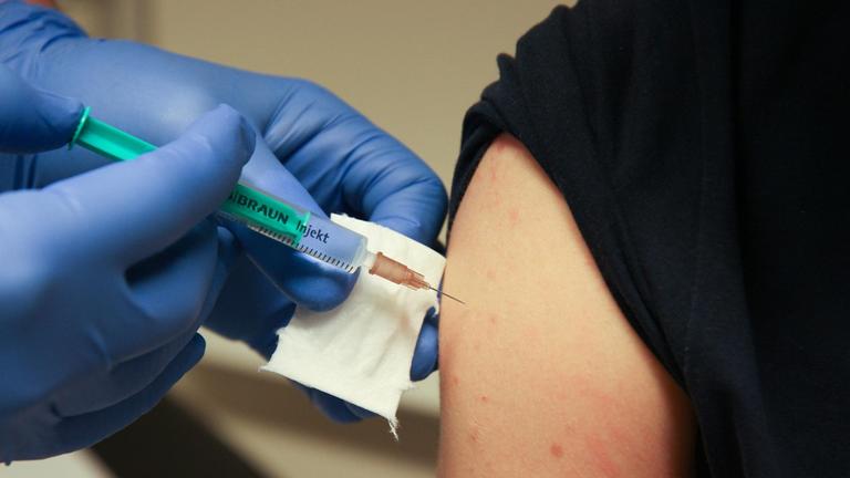 Impfen eines Patienten mit einer Spritze durch einen Arzt