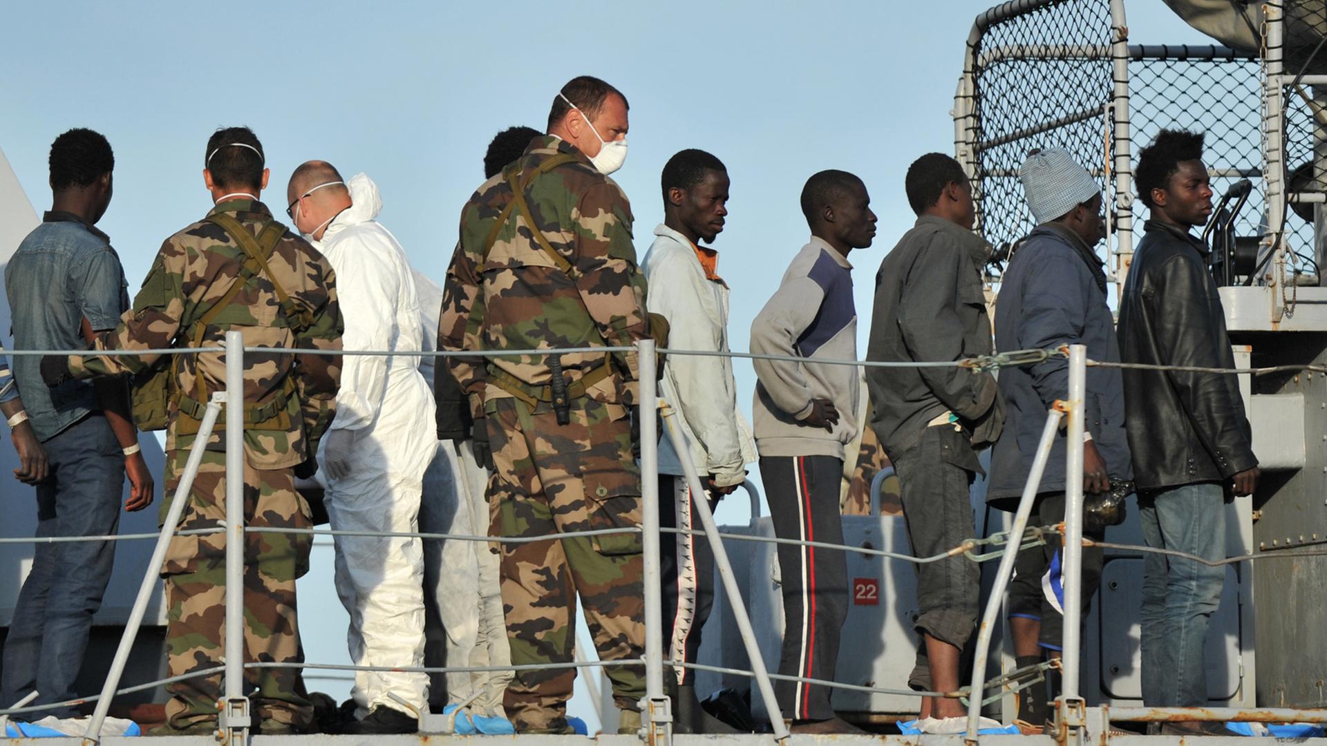 Migranten an Bord des französischen Militärschiffs "Birot" im Hafen von Crotone. Am Wochenende wurden mehr als 5.800 Flüchtlinge aus Seenot im Mittelmeer gerettet. Migranten an Bord des französischen Militärschiffs "Birot" im Hafen von Crotone. Am Wochenende wurden mehr als 5.800 Flüchtlinge aus Seenot im Mittelmeer gerettet.