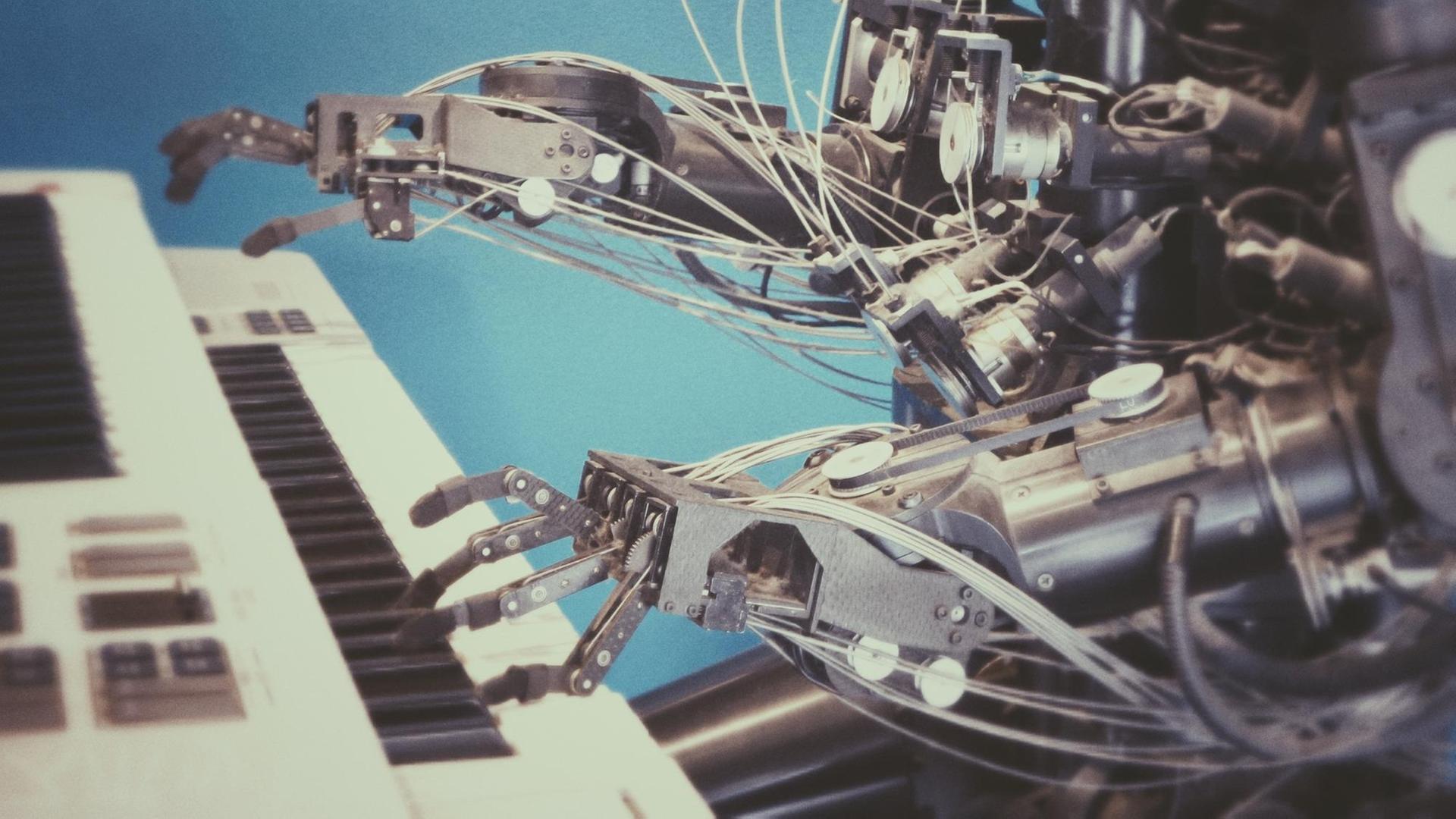 Ein Roboter spielt auf einem Keyboard. Ein Roboter spielt auf einem Keyboard.