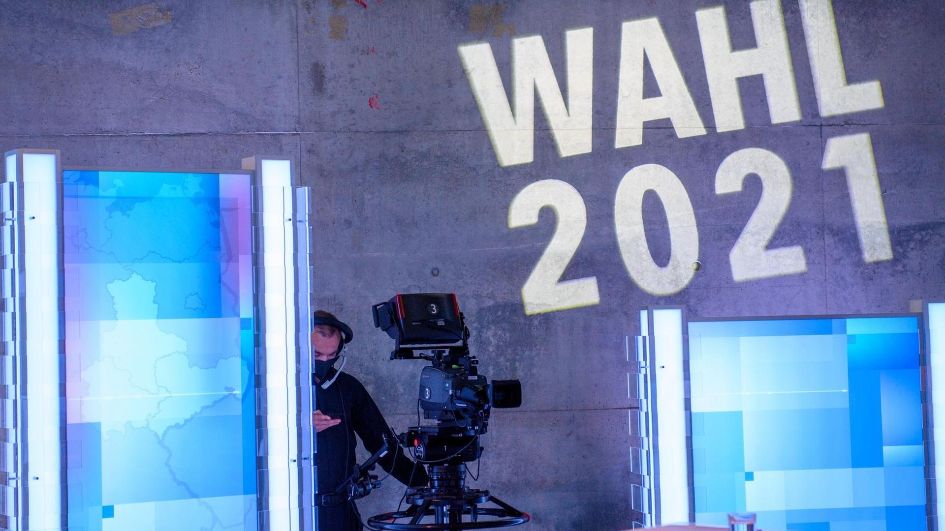 Eine Kamera steht in der MDR-Wahlarena im MDR-Landesfunkhaus unter den Worten "Wahl 2021" die an die Wand projiziert sind. Eine Kamera steht in der MDR-Wahlarena im MDR-Landesfunkhaus unter den Worten "Wahl 2021" die an die Wand projiziert sind.