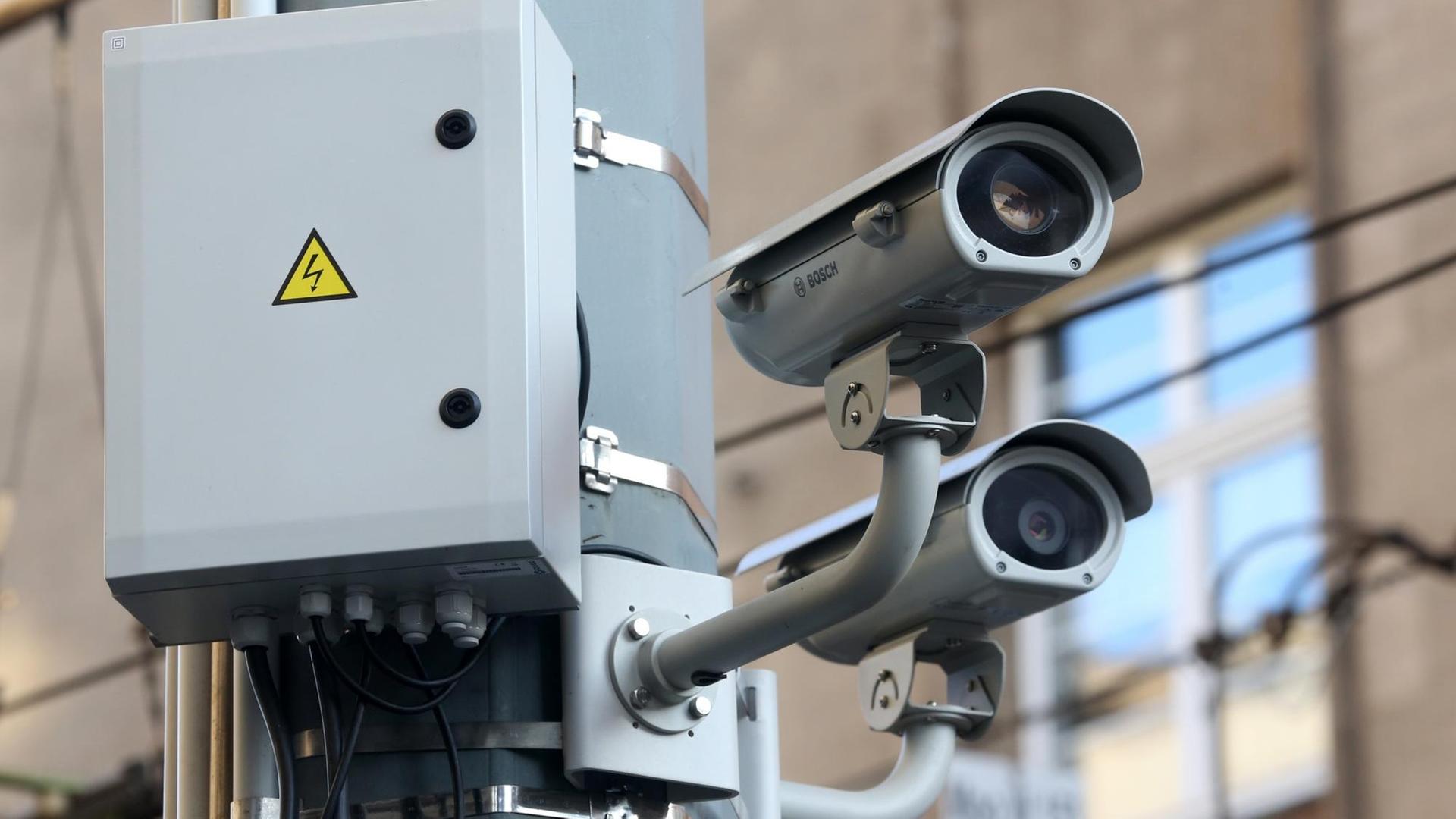 Zwei Videokameras hängen in Duisburg an einem Laternenpfahl.