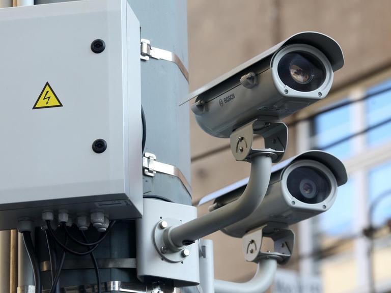 Zwei Videokameras hängen in Duisburg an einem Laternenpfahl.