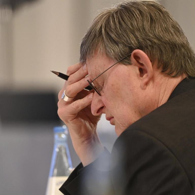 Kardinal Rainer Maria Woelki hält sich bei der Vorstellung des Gutachtens die Hand an den Kopf