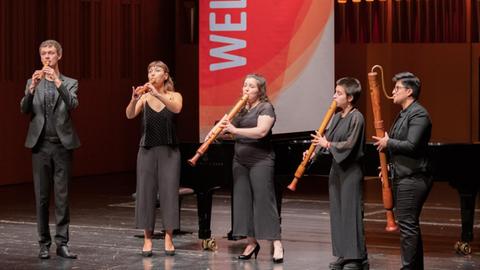 Vier Blockflötisten stehen auf einer großen Bühne im Konzert