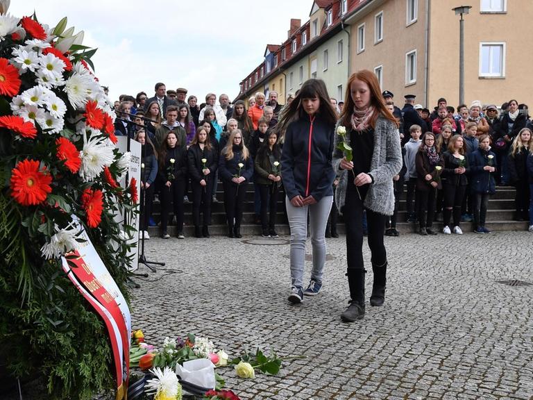 Bei einer Gedenkfeier vor dem Gutenberg-Gymnasium legen Schüler am 26.04.2017 in Erfurt (Thüringen) weiße Rosen nieder.