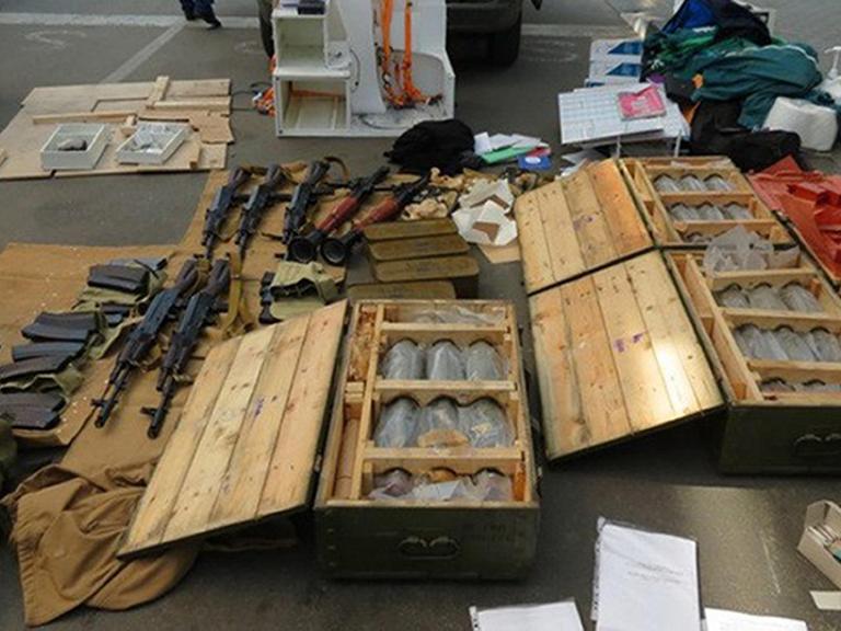 Waffen und Sprengstoff liegen auf einem Tisch.