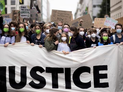 In Berlin demonstrieren viele junge Menschen gegen die Klimakrise. In der ersten Reihe steht Greta Thunberg hinter einem Banner mit der Aufschruft "Justice".