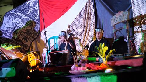Zwei indonesische Musiker vor farbenfrohen Tüchern