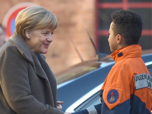 Der 12-jährige Leonel begrüßt am 14.11.2016 Bundeskanzlerin Angela Merkel (CDU) bei der Jugendfeuerwehr Wedding in Berlin. Anlass für den Besuch der Kanzlerin ist der Integrationsgipfel der Bundesregierung. Bei der Jugendfeuerwehr Wedding kommt die Hälfte der 62 Mitglieder aus Einwandererfamilien.