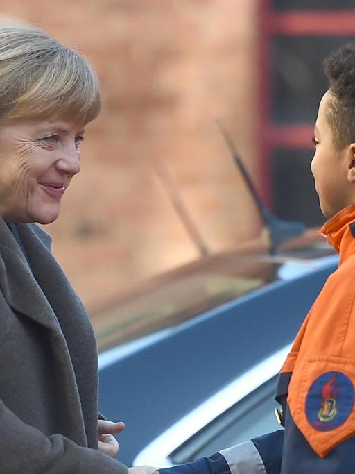 Der 12-jährige Leonel begrüßt am 14.11.2016 Bundeskanzlerin Angela Merkel (CDU) bei der Jugendfeuerwehr Wedding in Berlin. Anlass für den Besuch der Kanzlerin ist der Integrationsgipfel der Bundesregierung. Bei der Jugendfeuerwehr Wedding kommt die Hälfte der 62 Mitglieder aus Einwandererfamilien.