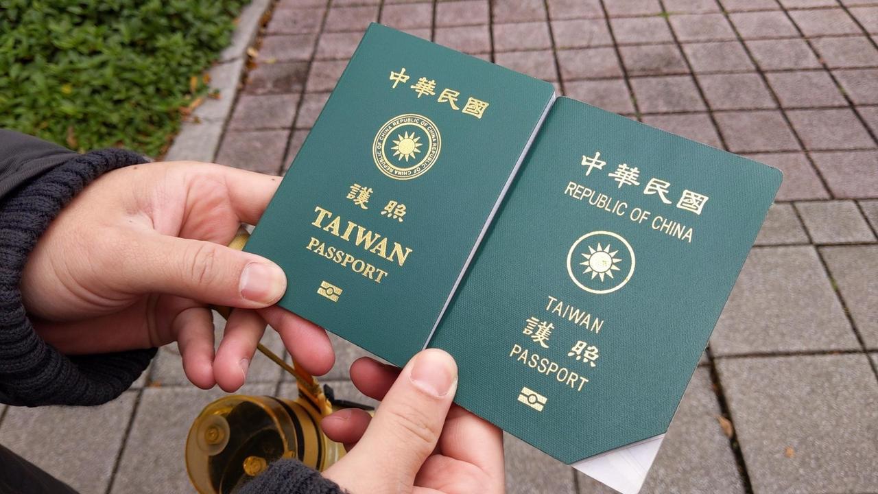 Zwei Hände halten taiwanesische Reisepässe in altem und neuem Design nebeneinander. Zwei Hände halten taiwanesische Reisepässe in altem und neuem Design nebeneinander.