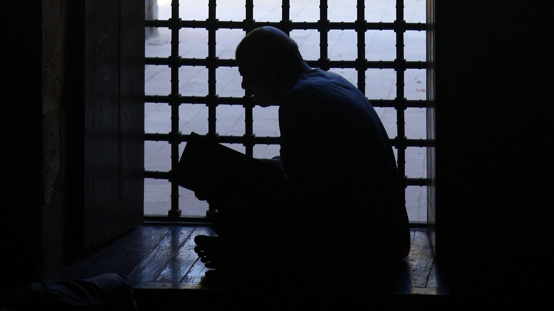Ein Mann liest im Koran.