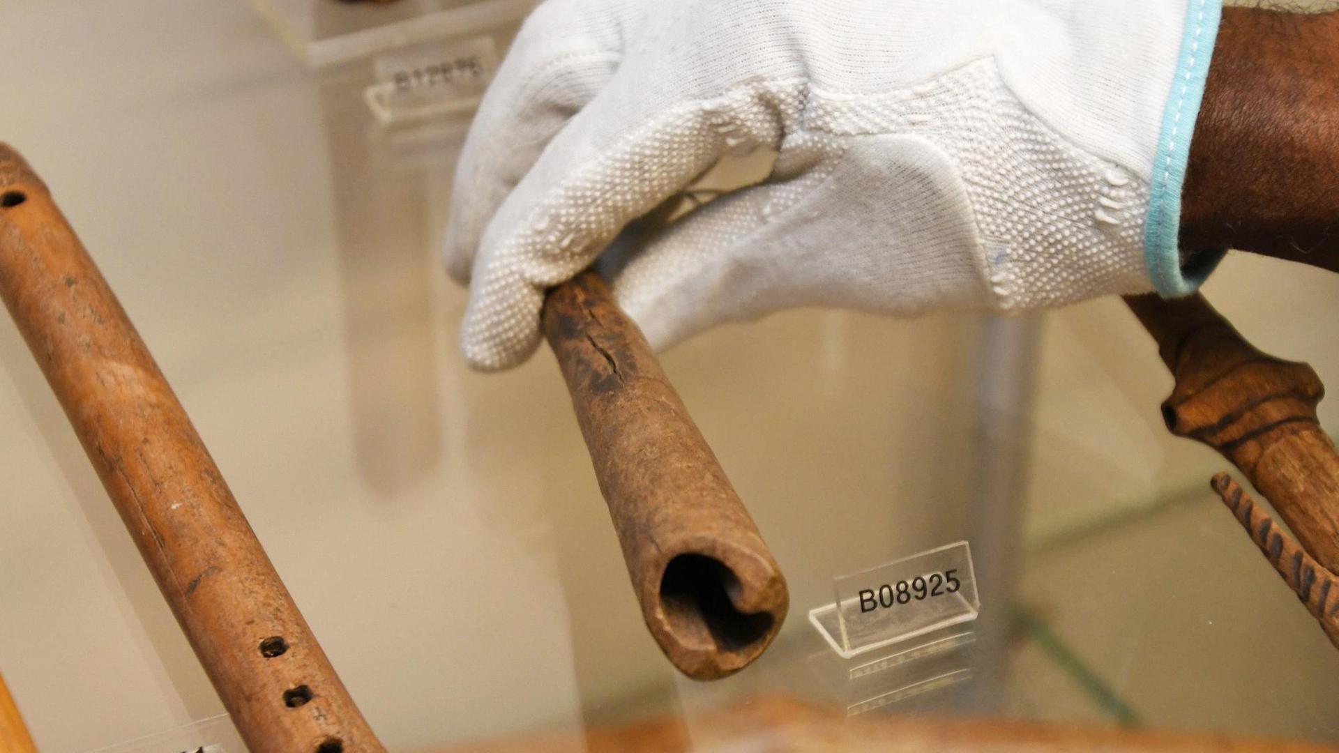 Bremen: Der Wissenschaftler Ndzodo Awono legt im Schaumagazin des Überseemuseums eine Pfeife aus Kamerun zurück an ihren Platz. Bremen: Der Wissenschaftler Ndzodo Awono legt im Schaumagazin des Überseemuseums eine Pfeife aus Kamerun zurück an ihren Platz.