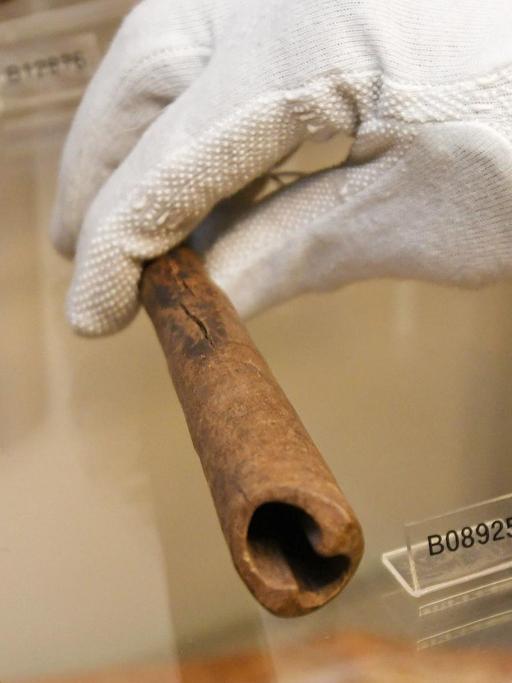 Bremen: Der Wissenschaftler Ndzodo Awono legt im Schaumagazin des Überseemuseums eine Pfeife aus Kamerun zurück an ihren Platz.