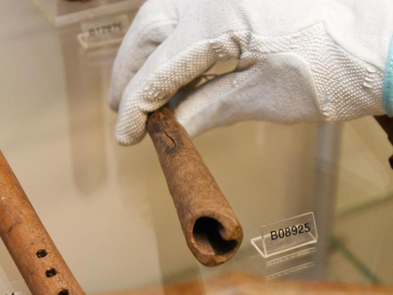 Bremen: Der Wissenschaftler Ndzodo Awono legt im Schaumagazin des Überseemuseums eine Pfeife aus Kamerun zurück an ihren Platz.