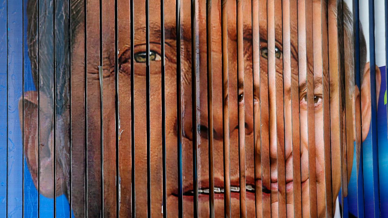 Eine rotierende Werbeanzeige in Tel Aviv zeigt die Porträts von Itzhak Herzog und Benjamin Netanjahu ineinander übergehend. Eine rotierende Werbeanzeige in Tel Aviv zeigt die Porträts von Itzhak Herzog und Benjamin Netanjahu ineinander übergehend.