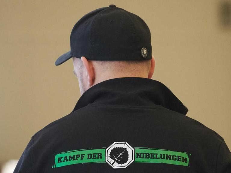 Das Foto zeigt in der Rückansicht einen der Angeklagten im Verfahren gegen mutmaßliche Mitglieder des «Aktionsbüros Mittelrhein». Sein Shirt trägt die Aufschrift "Kampf der Nibelungen - Disziplin ist alles!".