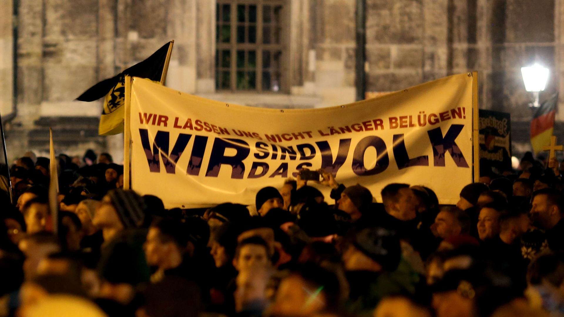 Pegida-Demonstranten halten ein Tranparent hoch, auf dem "Wir sind das Volk" steht. Pegida-Demonstranten halten ein Tranparent hoch, auf dem "Wir sind das Volk" steht.