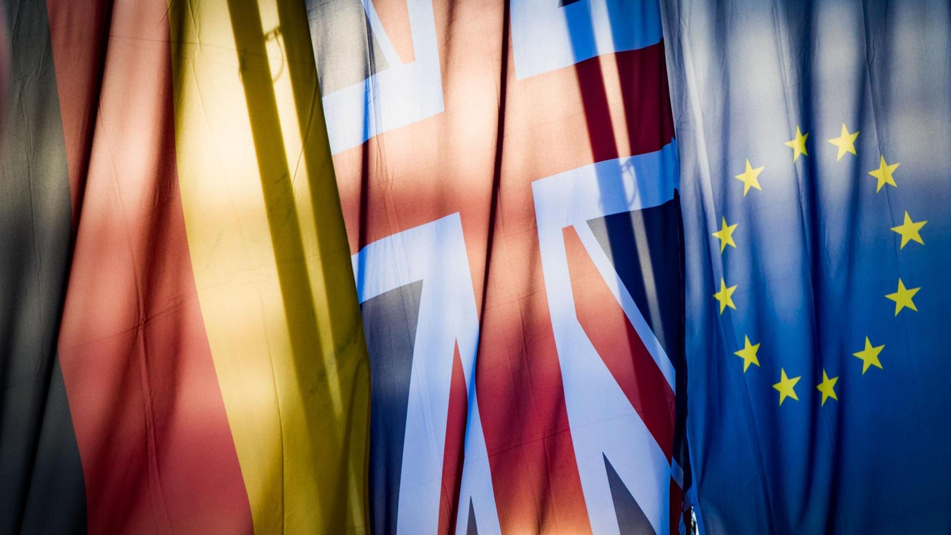 Eine deutsche, eine britische und eine europäische Flagge hängen nebeneinander. Eine deutsche, eine britische und eine europäische Flagge hängen nebeneinander.