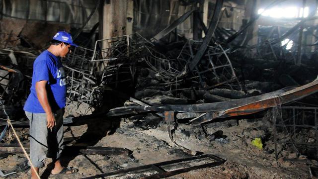 Ein pakistanischer Helfer steht in der ausgebrannten Textilfabrik in Karachi, Pakistan, am Tag nach der Brandkatastrophe.