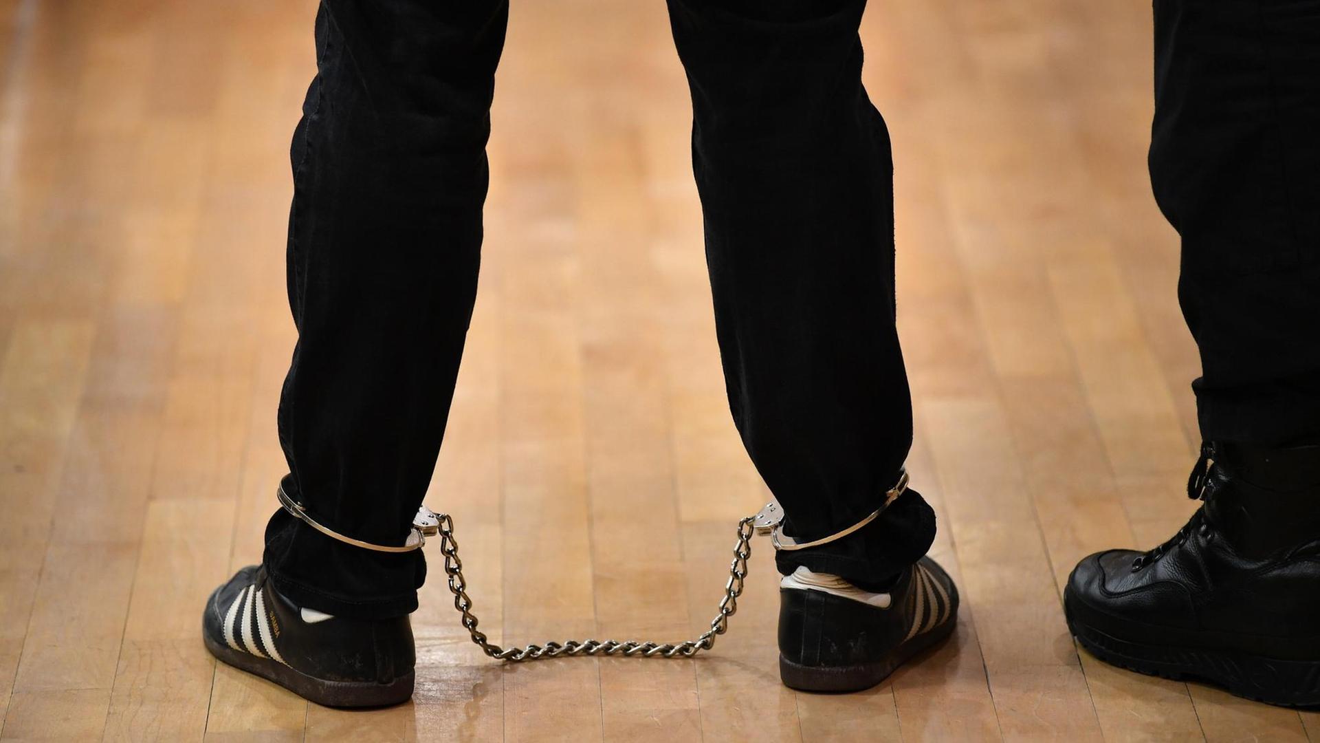Ein Angeklagter steht mit Fußfesseln vor Beginn der Neuauflage des Ballstädt-Prozesses im Congresszentrum der Messe Erfurt.