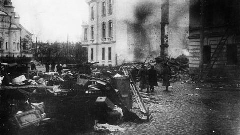 Ein Schwarzweiß-Foto zeigt Barrikaden und dahinter verschanzte Kämpfer und Rauchschwaden in einem Straßenzug von Kronstadt während des dortigen Matrosenaufstands 1921