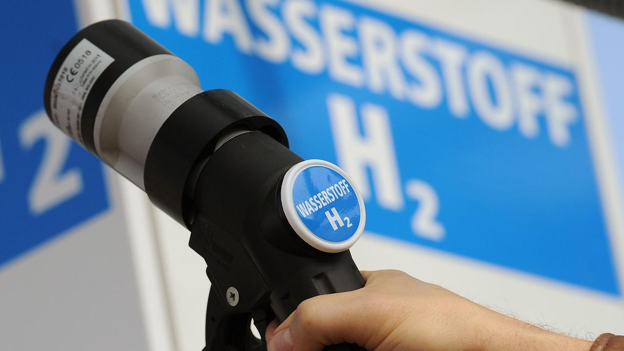 Ein Mann hält den Zapfhahn einer Wasserstoff-Tanksäule an ein Auto auf einer Tankstelle in Berlin.