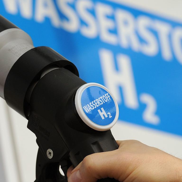 Ein Mann hält am 18.04.2012 den Zapfhahn einer Wasserstoff-Tanksäule an ein Auto auf einer Tankstelle in Berlin.