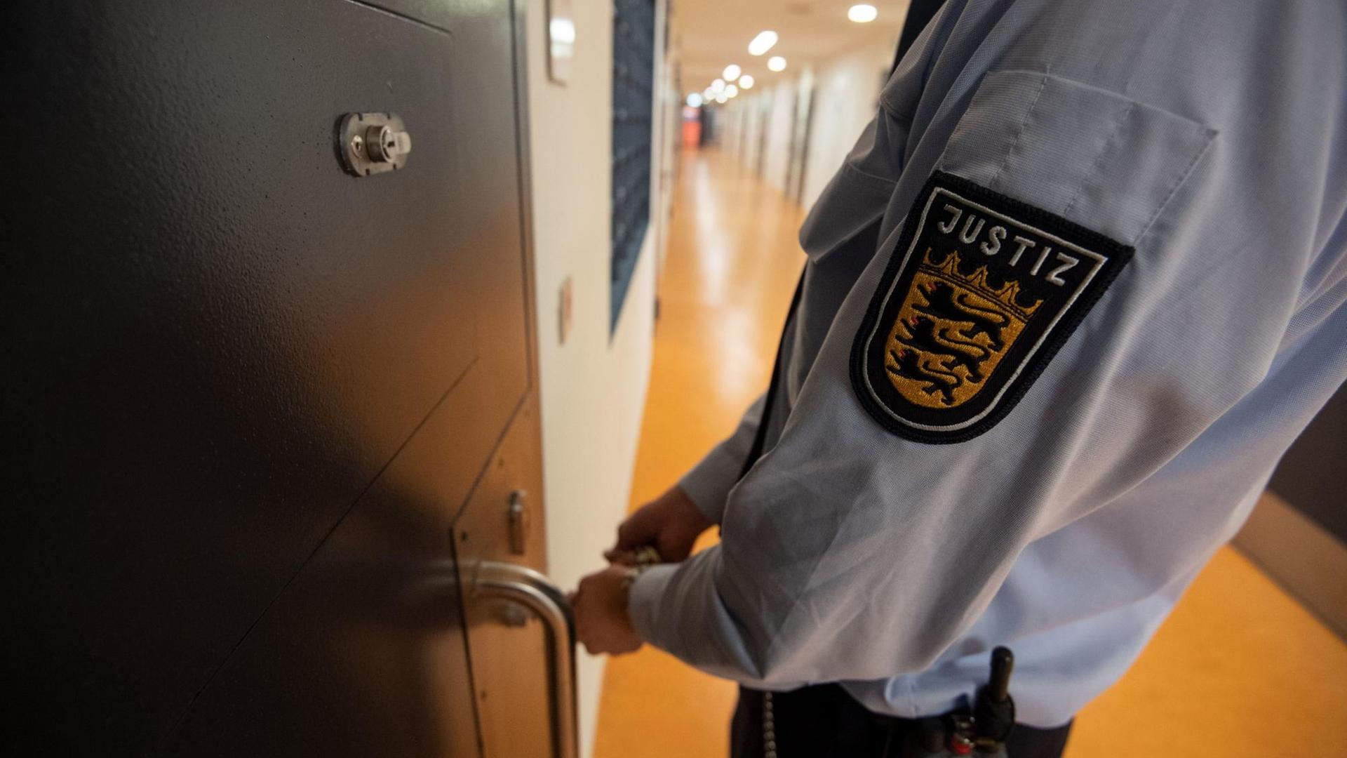 Ein Vollzugsbeamter der Justizvollzugsanstalt schließt eine Zellentür im Gefängnis auf. Ein Vollzugsbeamter der Justizvollzugsanstalt schließt eine Zellentür im Gefängnis auf.