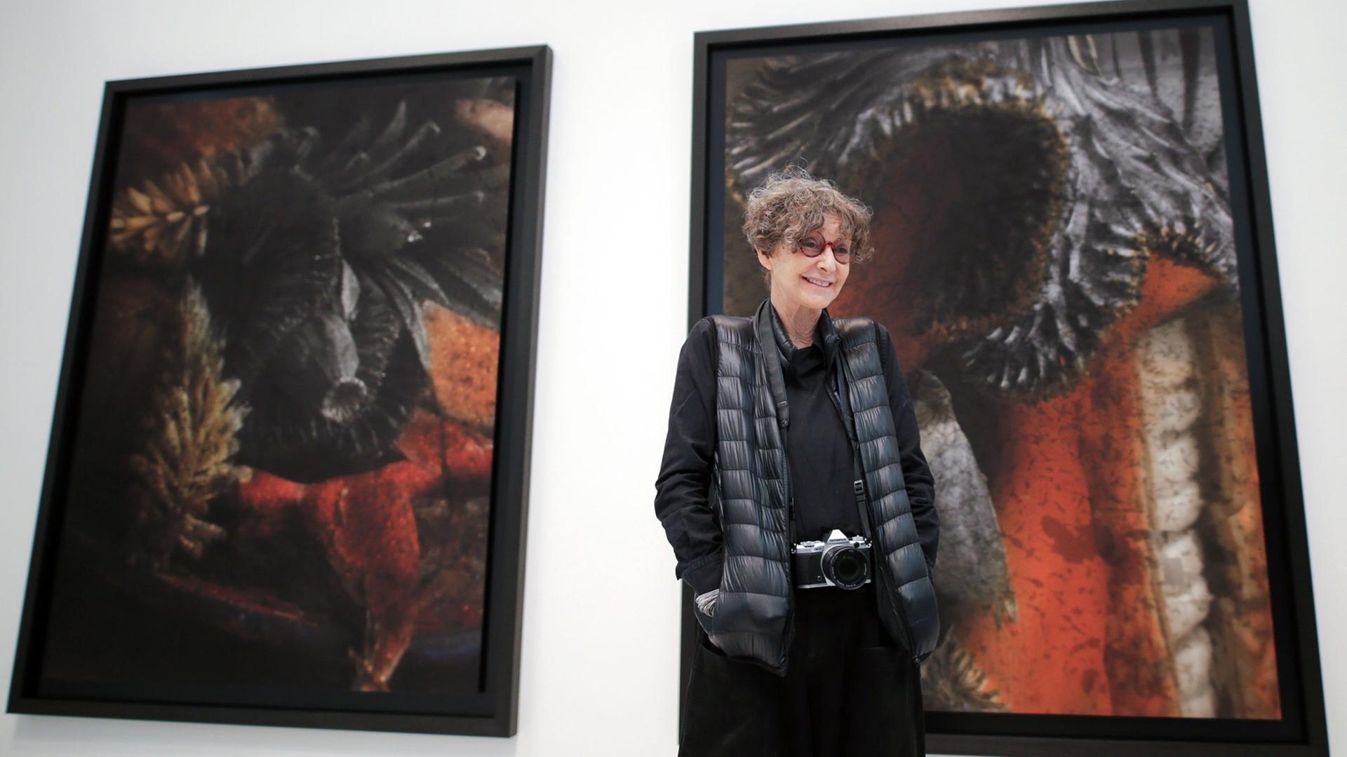 Die französische Fotografin Sarah Moon steht mit einer Kamera um den Hals vor Bildern ihrer Ausstellung in den Deichtorhallen in Hamburg Die französische Fotografin Sarah Moon steht mit einer Kamera um den Hals vor Bildern ihrer Ausstellung in den Deichtorhallen in Hamburg