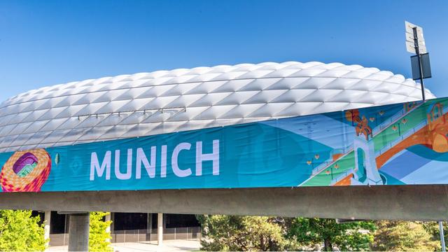 Ein Banner mit der Aufschrift „Munich“ hängt vor der Allianz-Arena in München.