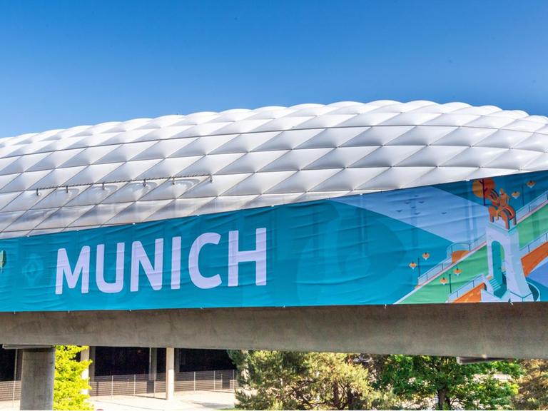 Ein Banner mit der Aufschrift „Munich“ hängt vor der Allianz-Arena in München.