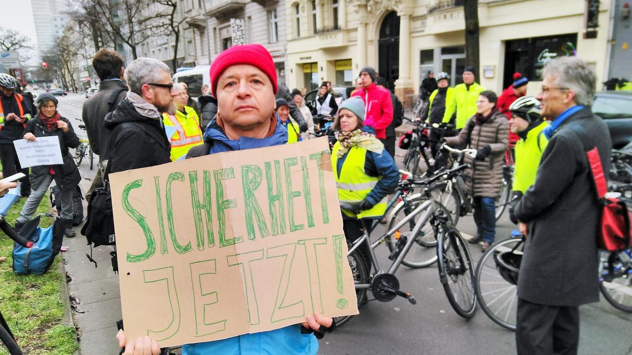 Ein Demonstrant hält ein Schild mit "Sicherheit Jetzt!" in die Kamera. Ein Demonstrant hält ein Schild mit "Sicherheit Jetzt!" in die Kamera.