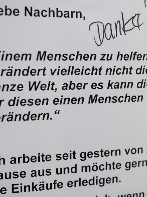 In einem Berliner Hochhaus hängt im Flur ein Zettel, in dem ein Bewohner Hilfe für seine Nachbarn bei Einkäufen anbietet. 26.März 2020, Berlin.