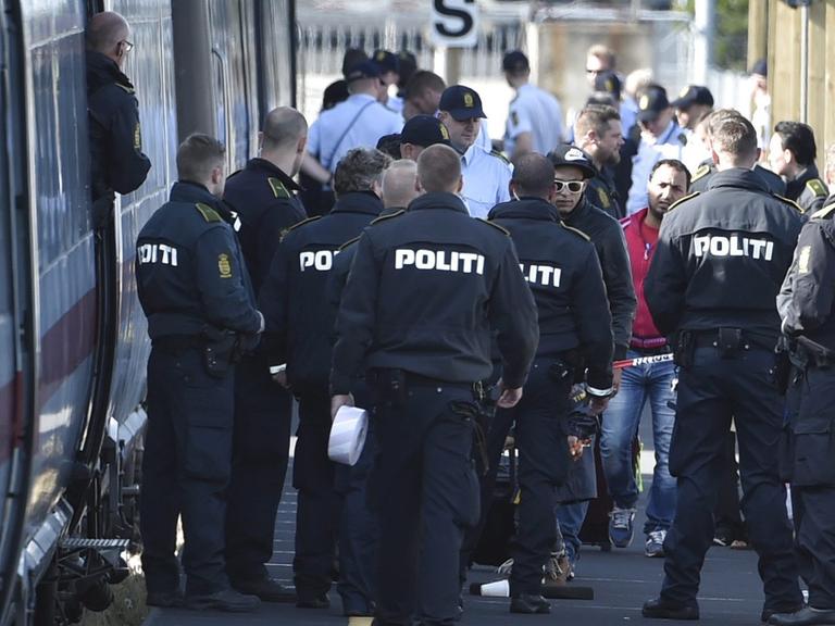 Dänische Polizisten stehen in Rødby vor einem ICE.